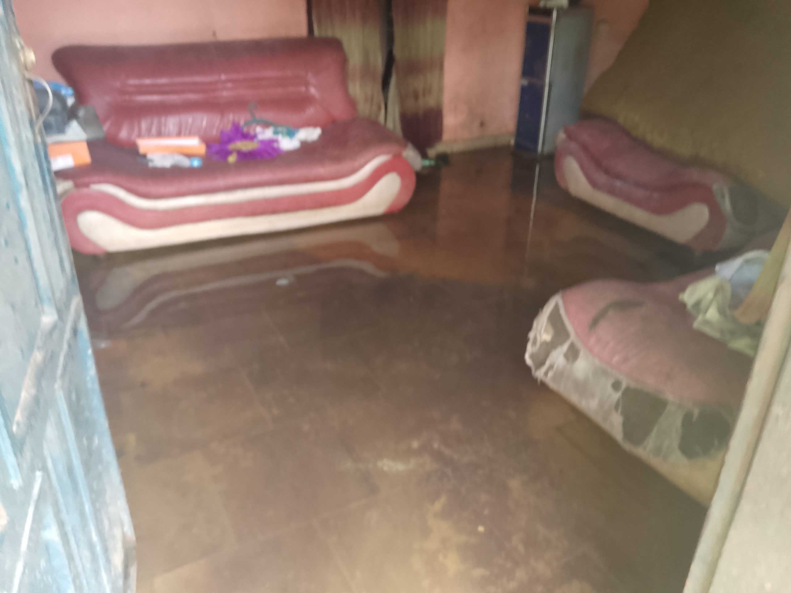 An Aged Woman Bailing Water Out Of Her Room In Edo State